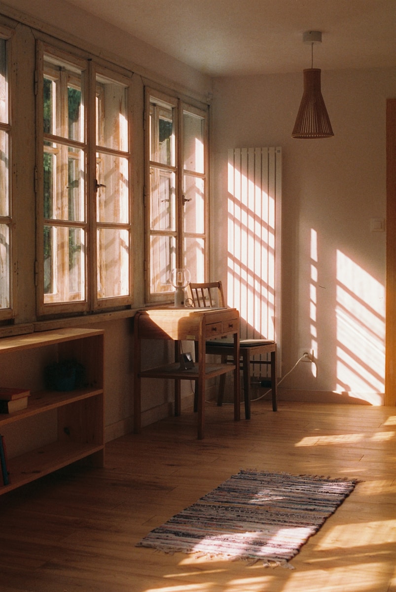 Sunlight streams into a cozy room with a desk.